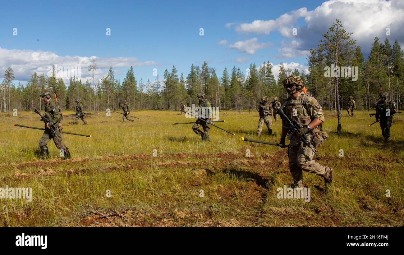 STATI UNITI Soldati assegnati a “Viper Company”, 1st battaglione, 26th reggimento fanteria, 2nd squadra di combattimento Brigata, 101st Divisione aerea (Assalto aereo) e coscritti delle forze di difesa finlandesi attraversano le paludi durante l’esercizio di fuoco a Rovaniemi, Finlandia, 11 agosto 2022. La Brigade Combat Team 2nd, 101st divisione Airborne (Air Assault) ha iniziato una formazione combinata in Finlandia per rafforzare le relazioni e costruire l'interoperabilità tra le due nazioni partner. Foto Stock