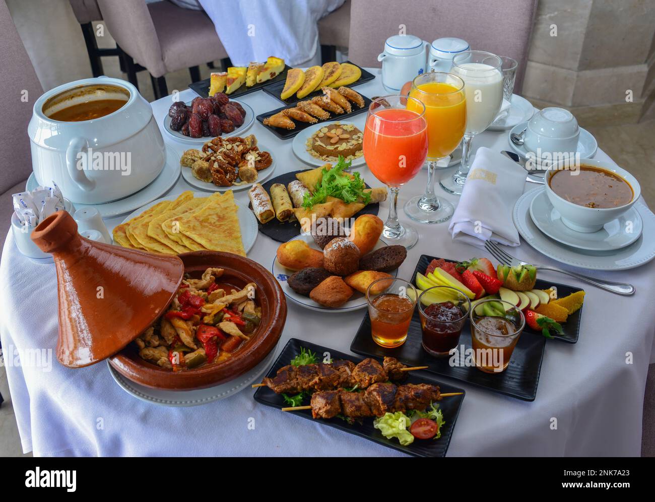 Colazione marocchina nel Ramadan. Zuppa di Harira. Datteri, tè, succhi di frutta e dolci vari Foto Stock