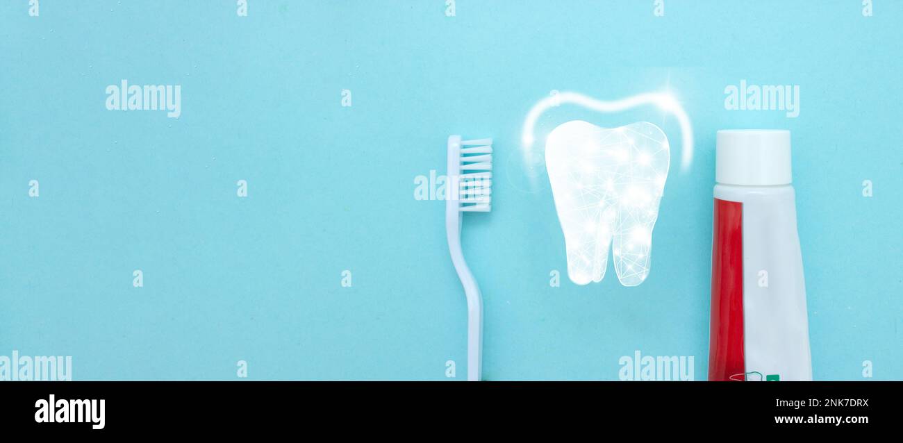 Primo piano di uno spazzolino da denti e dentifricio con sottile icona lineare Low Poly Tooth su sfondo blu sfocato. Concetto medico di stomatologia dentista orale Foto Stock