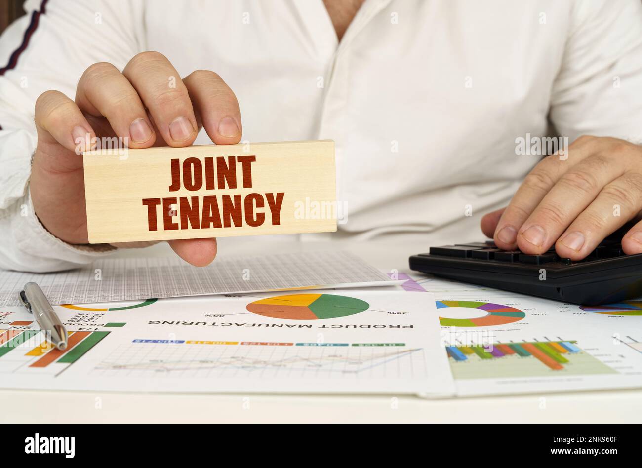 Concetto aziendale. Sulla tabella sono le tabelle di affari e i diagrammi nelle mani di un blocco di legno con l'iscrizione - LOCAZIONE CONGIUNTA Foto Stock
