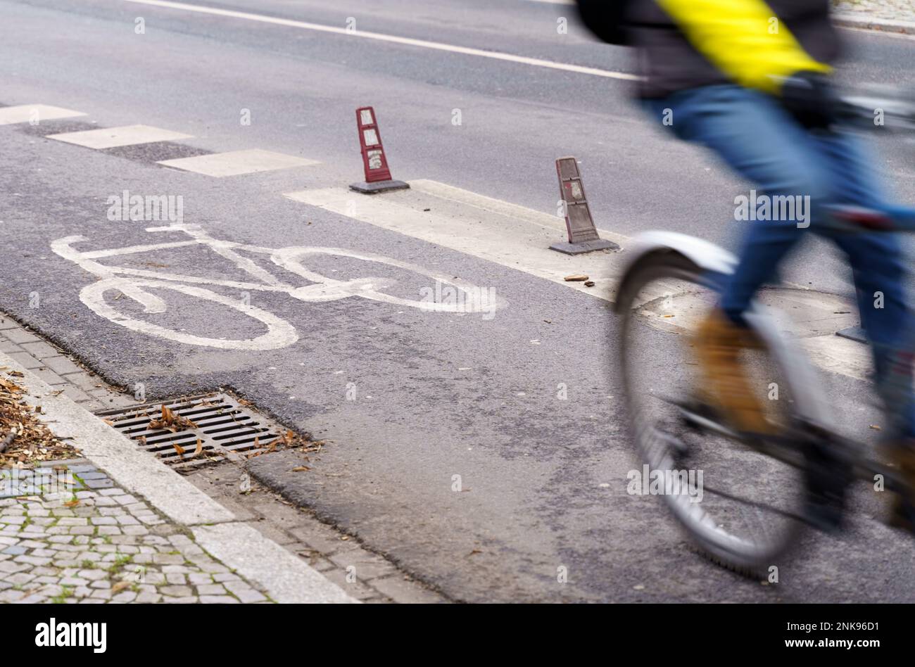 Il ciclista viaggia su una pista ciclabile. L'immagine di un ciclista è sfocata in movimento, un segno di una pista ciclabile in nitidezza Foto Stock