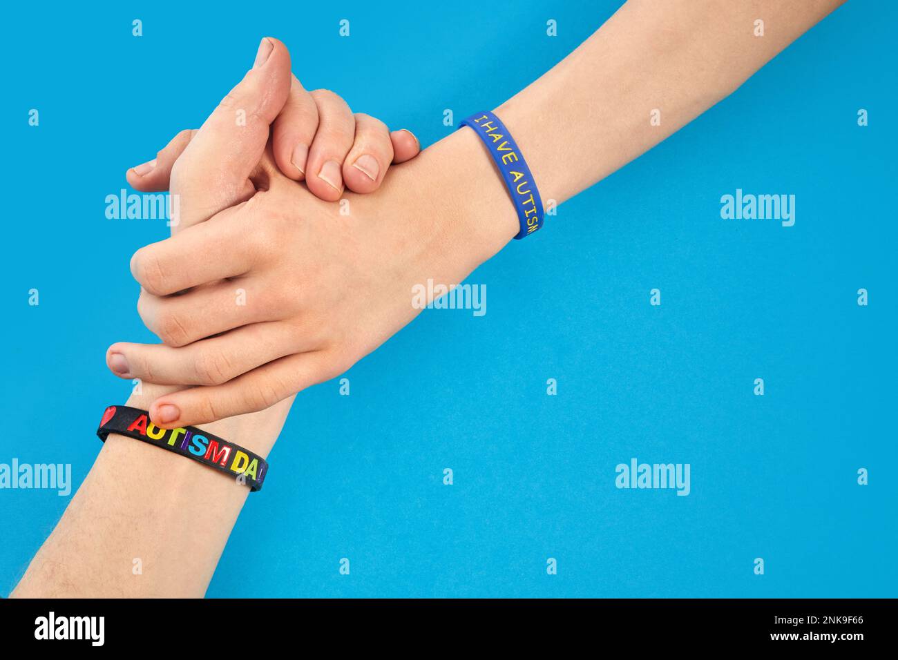 Consapevolezza dell'autismo. Autismo padre che tiene mano il suo bambino autistico con ho braccialetto autismo Foto Stock