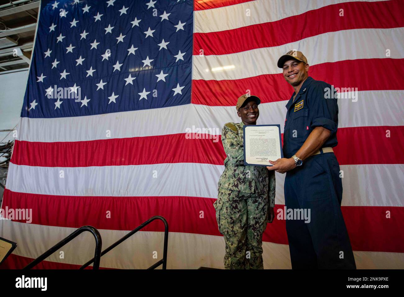 210812-N-OX029-2036 NORFOLK (12 agosto 2022) – Aviation Ordnance 3rd Class Aujane Haynes riceve Junior Sailor del quartiere dal Capt. Nakia Cooper, comandante della nave d'assalto anfibio USS Wasp (LHD 1). Il CO ha riconosciuto Haynes di fronte all'intero equipaggio della nave durante una chiamata a mani libere per la sua eccezionale prestazione. Foto Stock