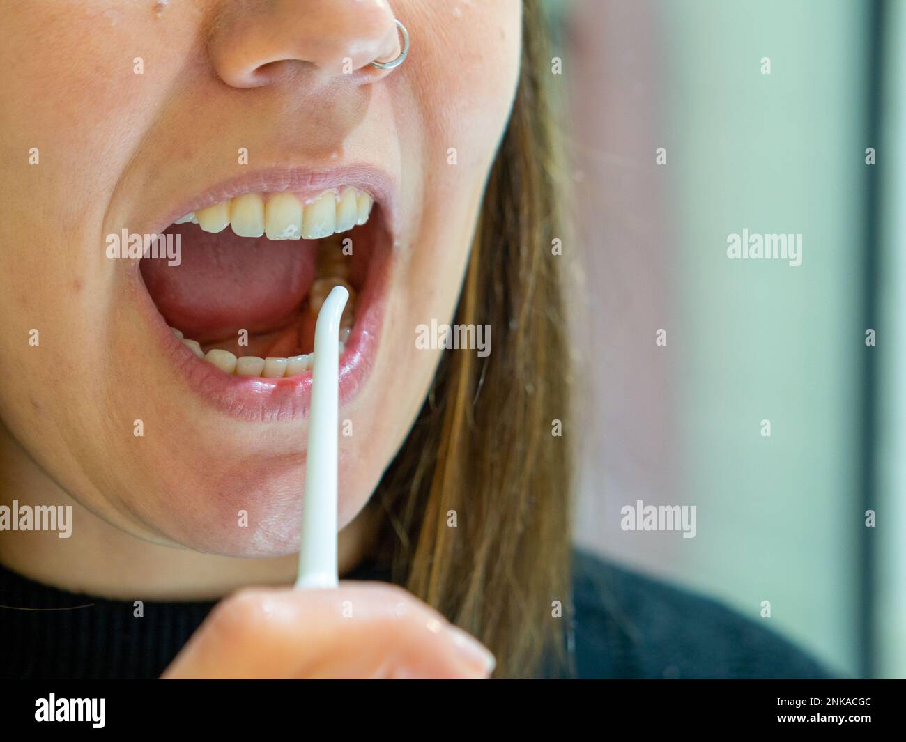 Igiene orale sana: Giovane donna che usa il flosser domestico dell'acqua dentale Foto Stock