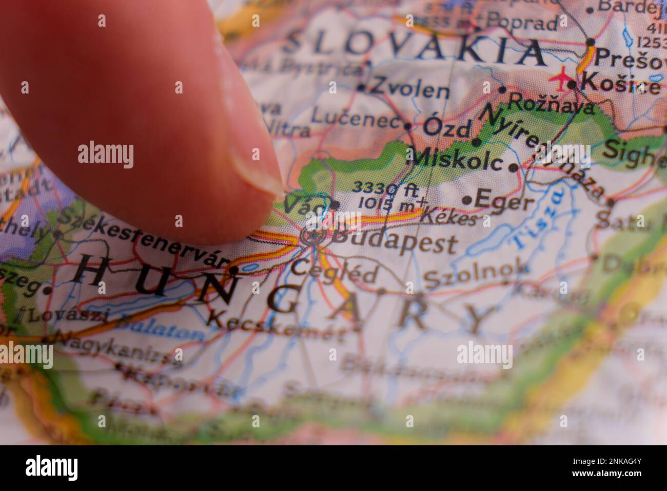 Un dito indica Budapest, Ungheria, su una mappa colorata con messa a fuoco selettiva, profondità di campo ridotta, sfocatura dello sfondo Foto Stock