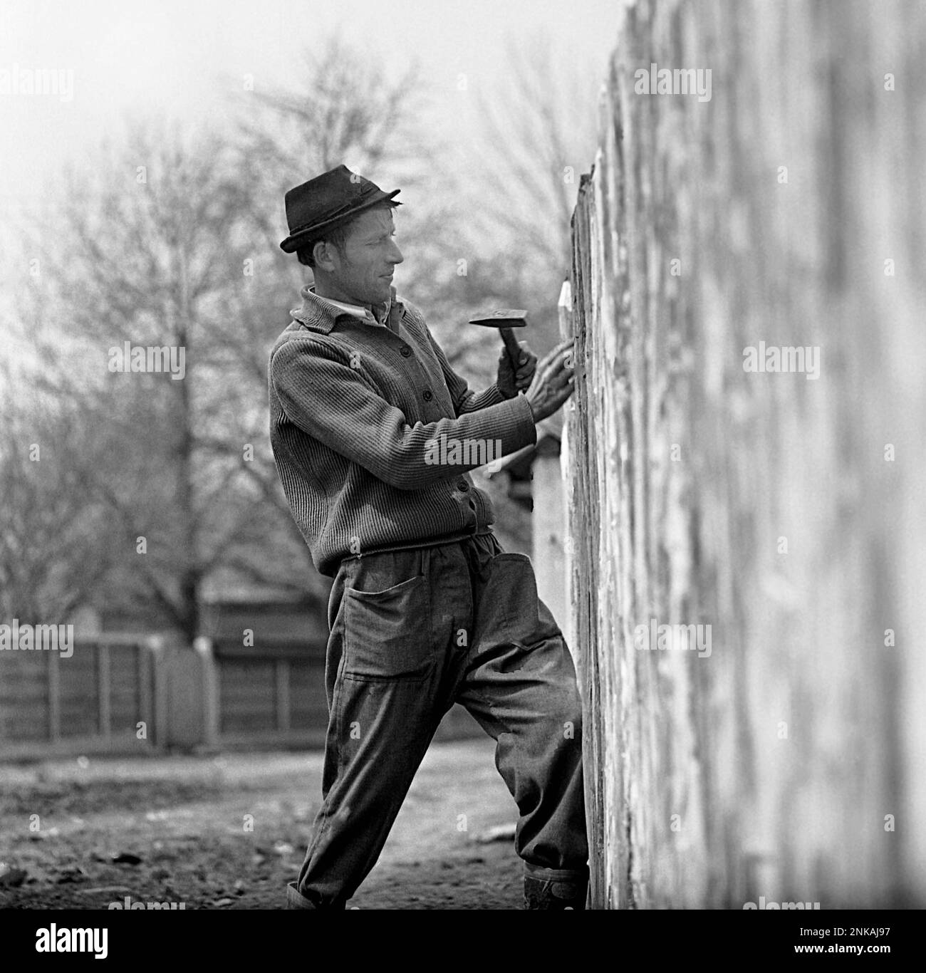 Contea di Suceava, Repubblica socialista di Romania, circa 1980. Villager che fissa una recinzione di legno. Foto Stock