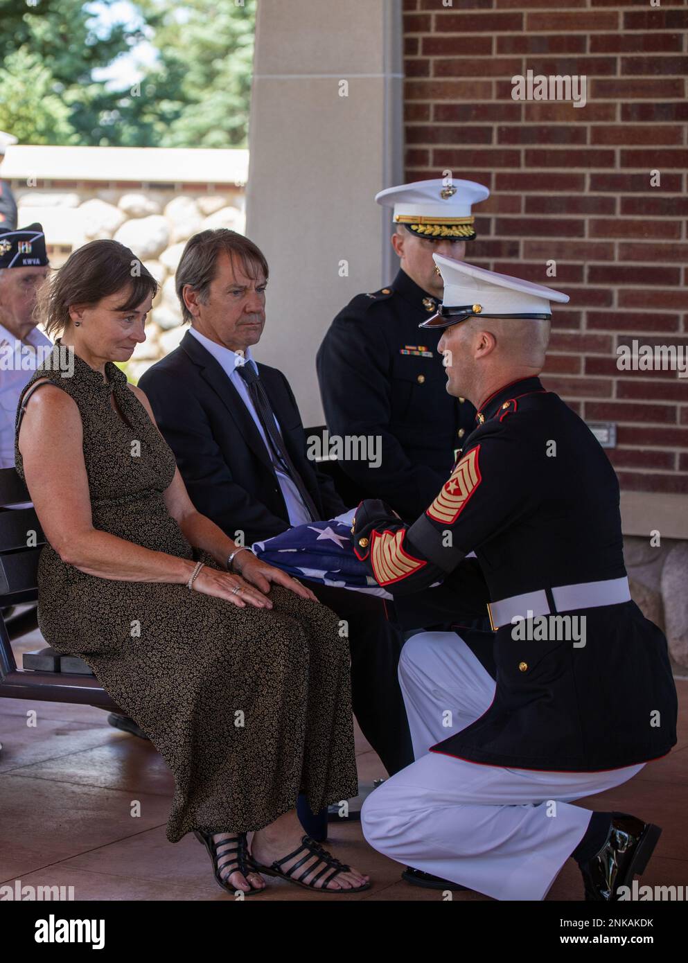 Timothy Babcock, l'ispettore-istruttore sergente maggiore per 1st Battaglione 24th Regimento Marino, presenta la bandiera americana piegata ad Ann C. Clark in onore del suo ultimo Padre, medaglia d'onore PFC. Robert E. Simanek (ritirato), al Great Lakes National Cemetery, Holly, Michigan 21 agosto 2022. Simanek si arruolò nel corpo dei Marine nel 1951 e fu dispiegato in Corea nel 1952. All'età di 22 anni saltò su una granata dal vivo per salvare i suoi compagni Marines e visse per raccontare la storia. Nell'ottobre del 1953 Simanek ha ricevuto la medaglia d'onore dal presidente Dwight D Eisenhower. Foto Stock