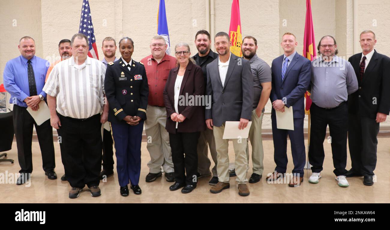 Il Col. Shari Bennett, comandante del Rock Island Arsenal-Joint Manufacturing and Technology Center, è in piedi con Floria Moore (centro), apprendista machinista laureato della classe di gennaio del 1982, e Mike Demoss (estrema destra), capo della divisione macchine RIA-JMTC, per presentare i dieci nuovi macchinisti di viaggio alla loro laurea in una cerimonia del 12 agosto. I laureati hanno completato un programma quadriennale che richiede una formazione accademica e un'esperienza pratica in tutti gli aspetti operativi della fabbrica. Da sinistra a destra, i laureati sono Shawn Behel, Joseph Findley, Jr.; Bryan Baum, Bryar Fuller, Charles Hender, Un Foto Stock