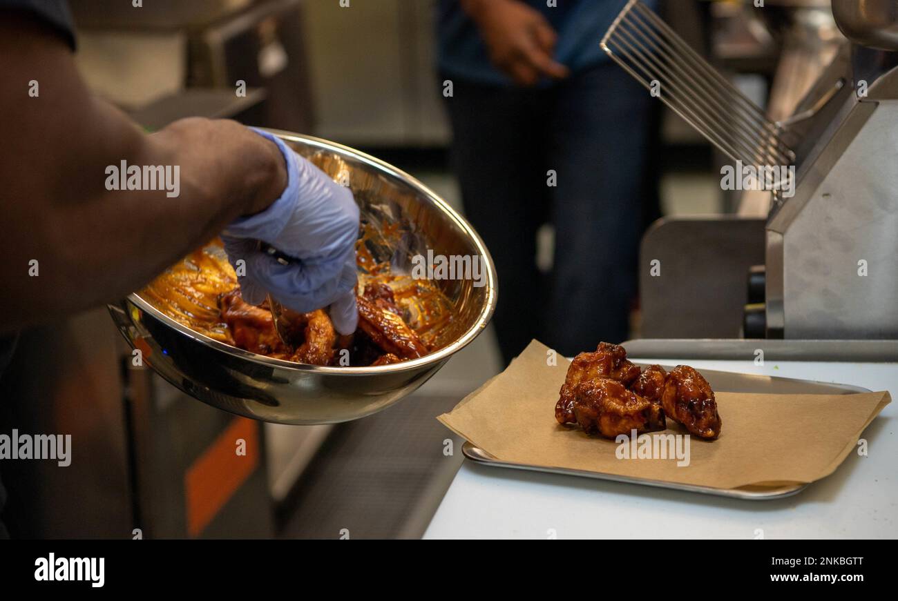 I cuochi del ristorante HEROES preparano il cibo nel Centro militare della Comunità di Kaiserslautern presso la base aerea di Ramstein, Germania, 12 agosto 2022. La squadra di cucina è composta da persone che hanno servito la comunità militare Kaiserslautern per più di cinque anni e sono dotate di abilità culinarie di diversi background. Foto Stock