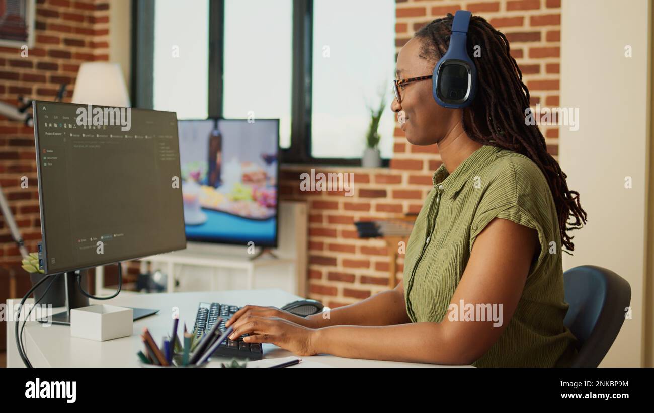 Giovane donna che lavora al programma DI SOFTWARE IT per creare database web con script e codice html. Programmazione dell'intelligenza artificiale sulla finestra del terminale, svolgendo un lavoro remoto da casa. Foto Stock