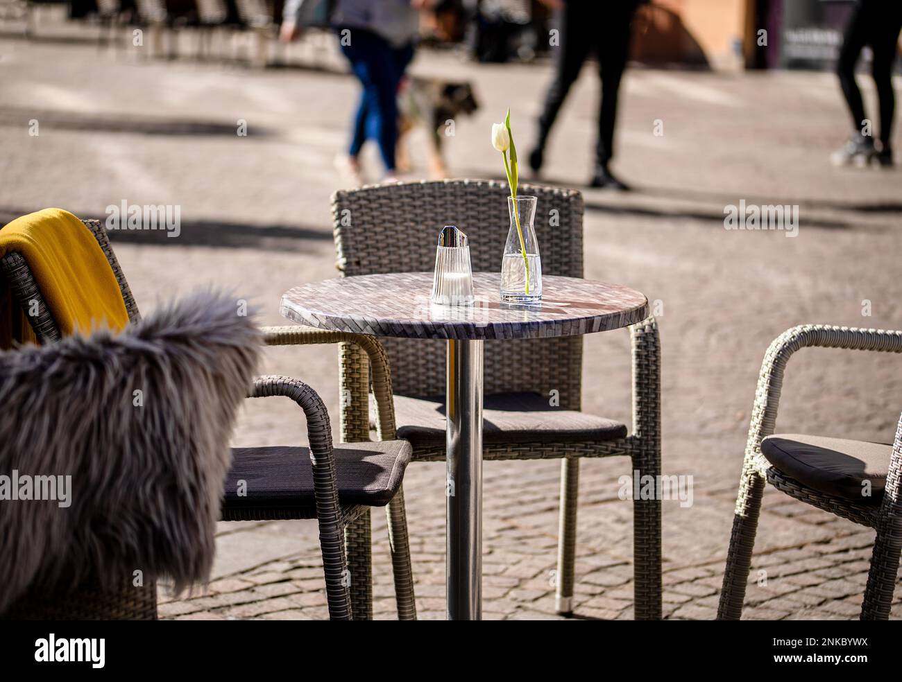 Tavoli vuoti fuori tra le ore di pranzo lungo un vicolo di ciottoli in una città europea, una veranda, un caffè Foto Stock