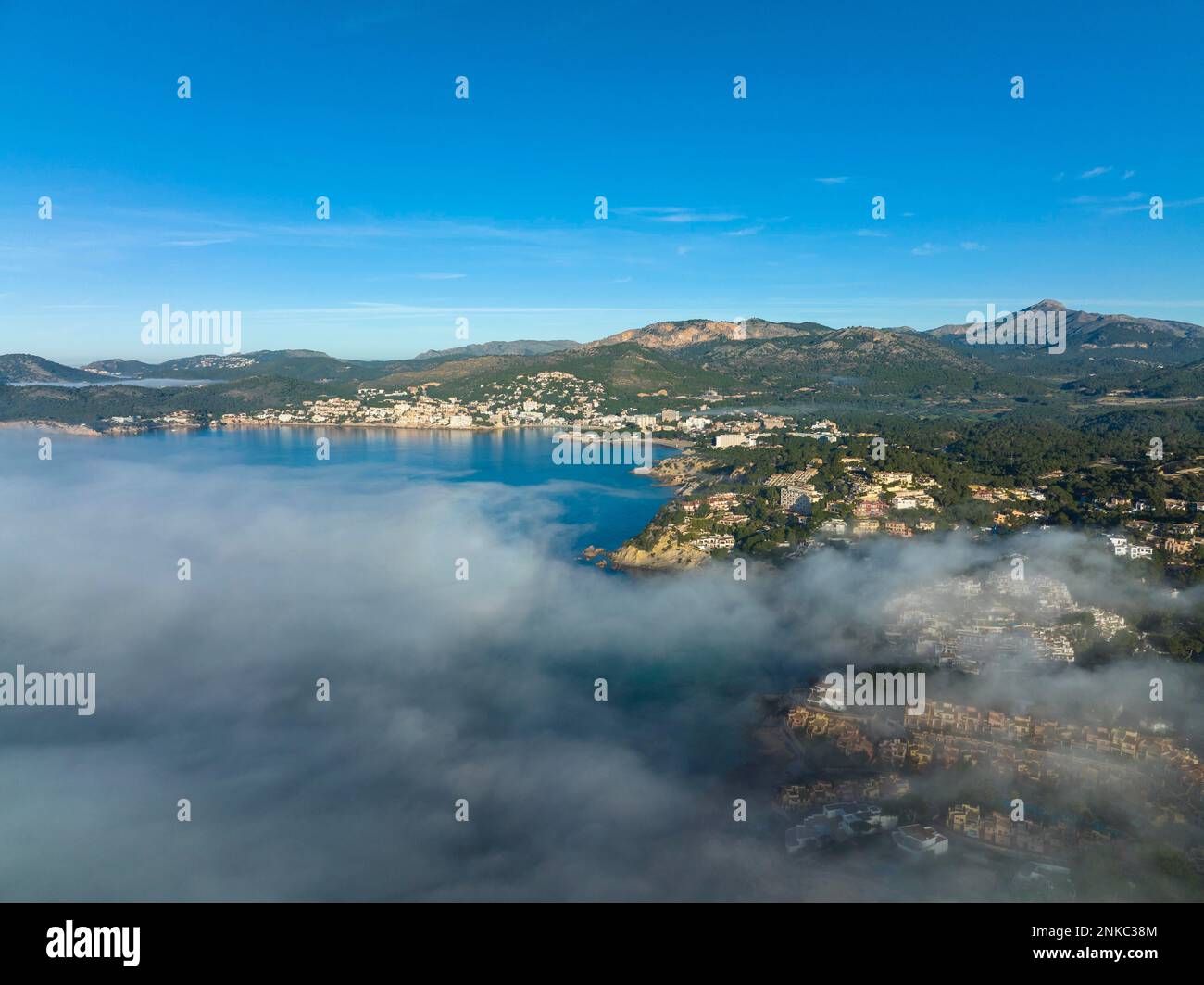 Vista aerea, volo sopra le nuvole, la costa di Maiorca nella nebbia con la città di Santa Ponca, Maiorca, Spagna Foto Stock