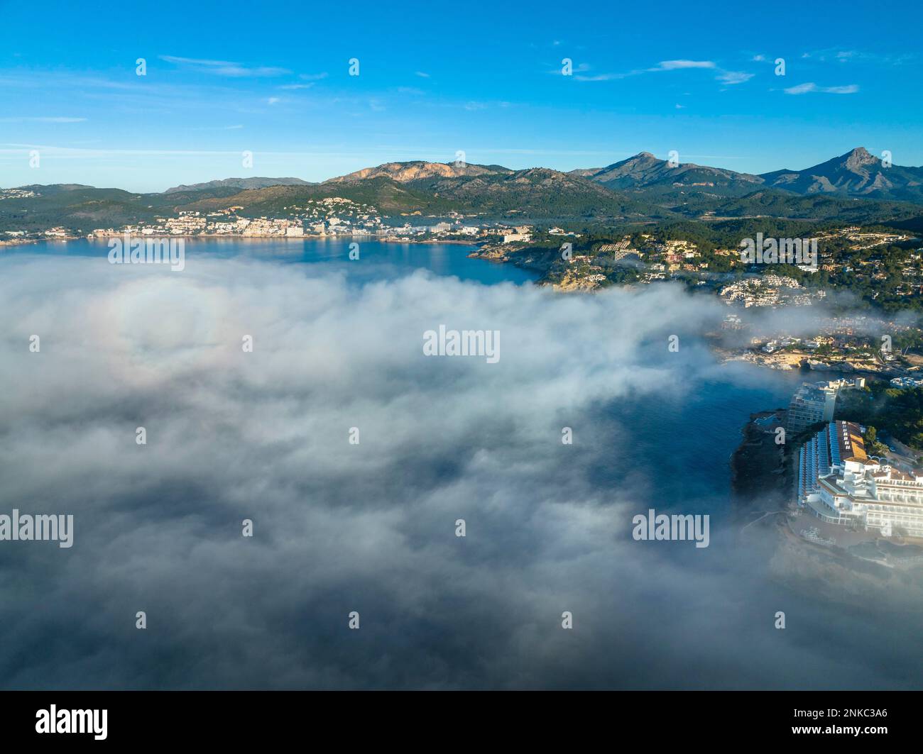 Vista aerea, volo sopra le nuvole, la costa di Maiorca nella nebbia con la città di Santa Ponca, Maiorca, Spagna Foto Stock