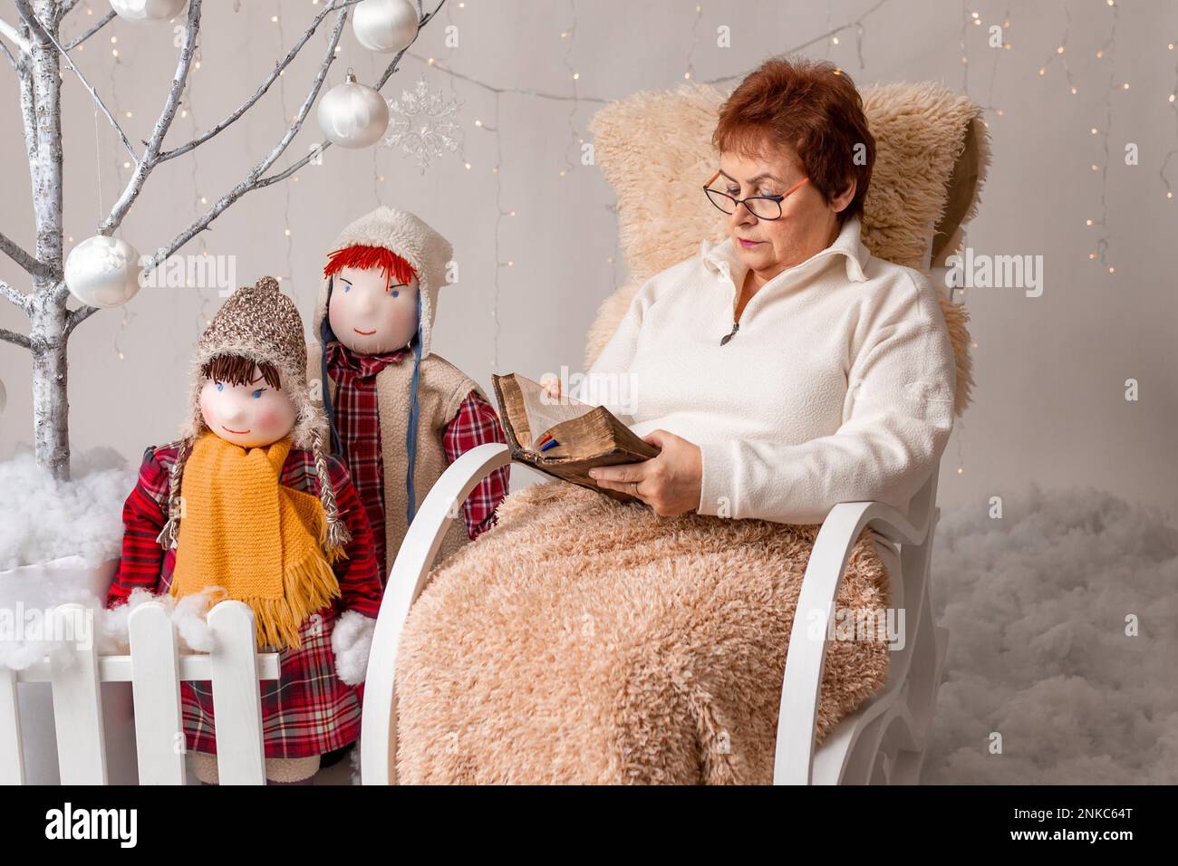 Una bella donna anziana legge un libro, Natale Foto Stock