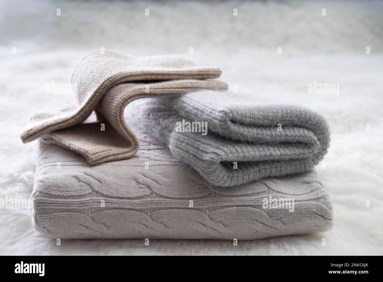 Maglieria invernale, cappello, scalda braccia e sciarpa, su pelliccia sintetica Foto Stock