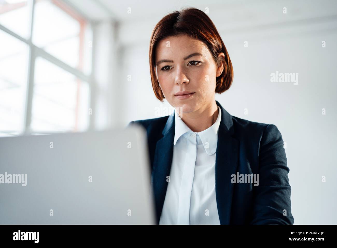 Donna d'affari che lavora sul laptop sul posto di lavoro Foto Stock