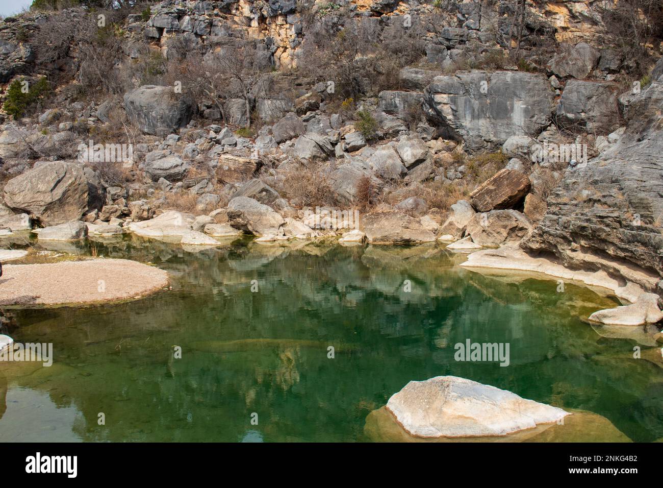 Granito geologico, calcare, rocce e massi creano uno sfondo per la piscina di acqua verde sottostante nel Pedernales Falls state Park Texas Foto Stock