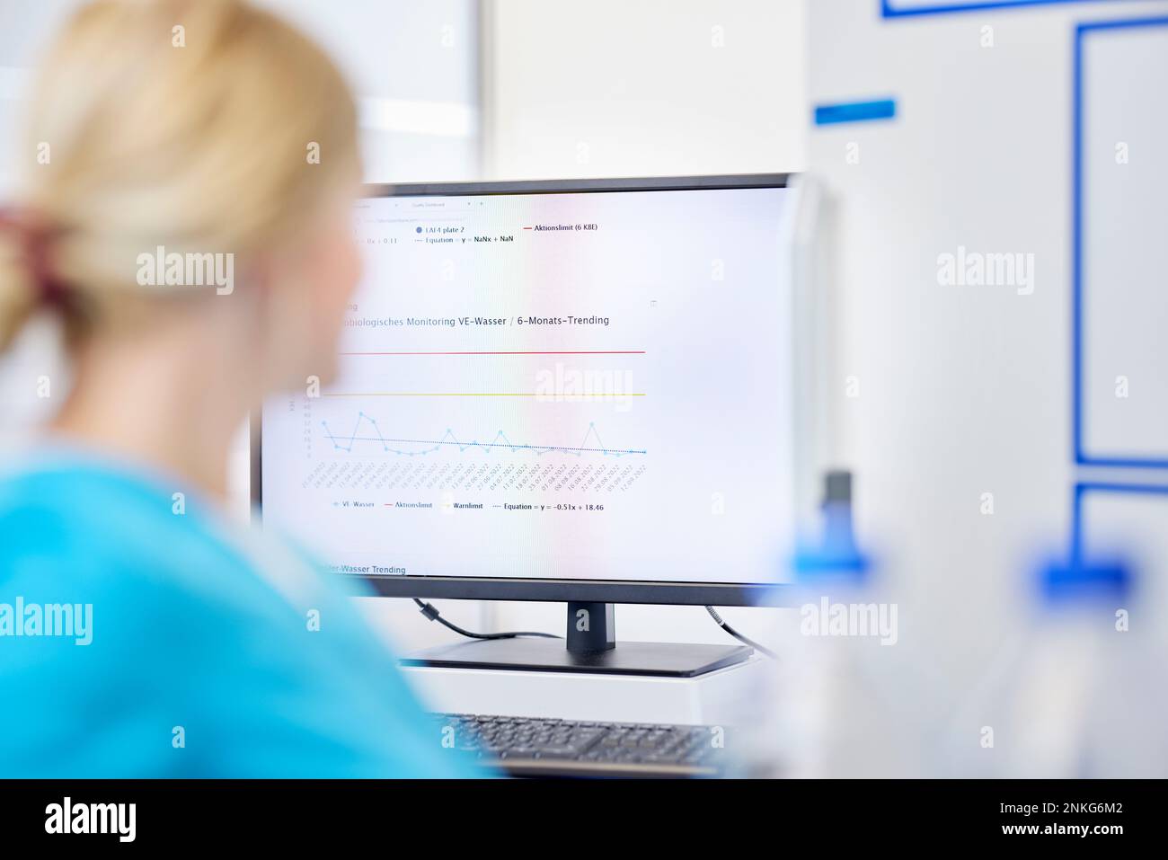 Scienziato femminile e risultati dei test sullo schermo del computer in un laboratorio Foto Stock