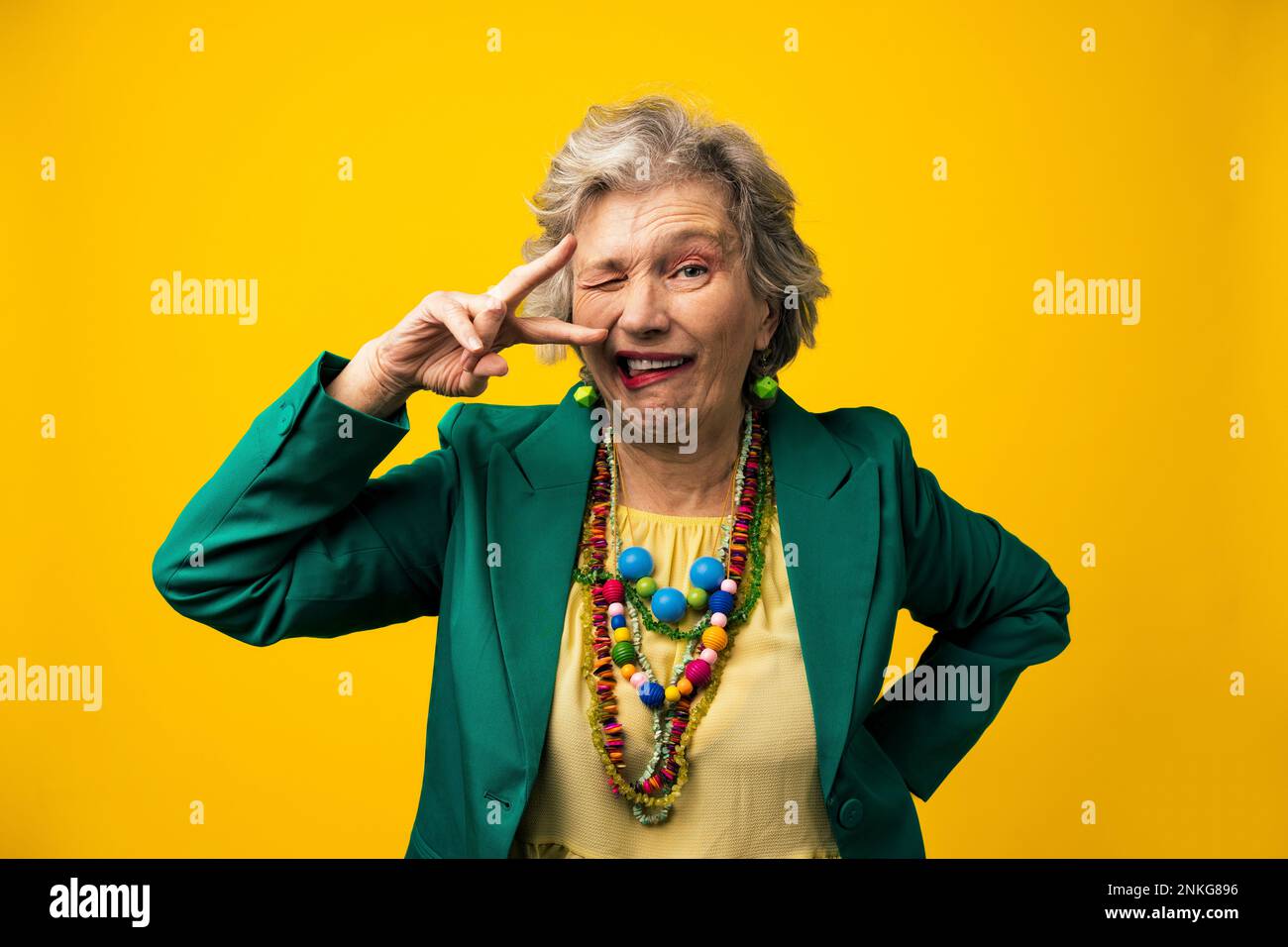 Donna anziana con espressioni facciali su sfondo giallo Foto Stock