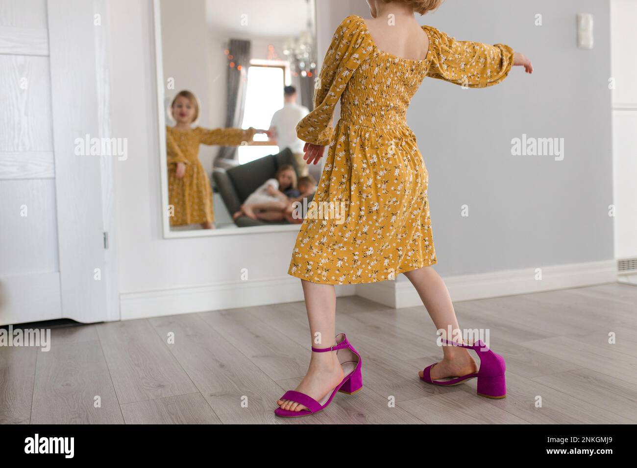 Ragazza che indossa le scarpe della madre che ballano di fronte allo specchio a casa Foto Stock
