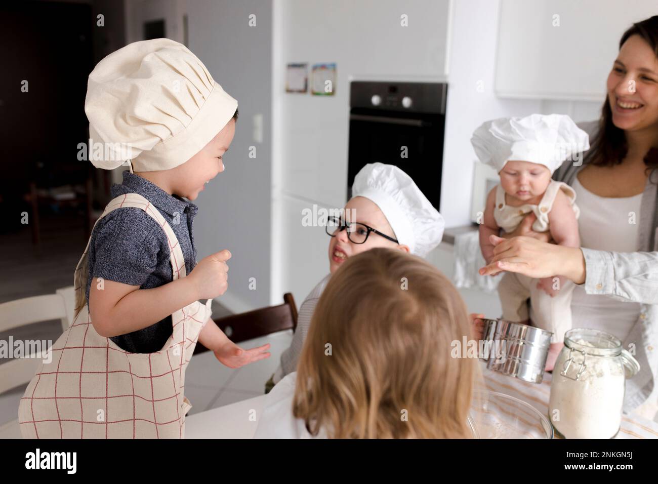 I bambini si divertono a preparare l'impasto in cucina Foto Stock