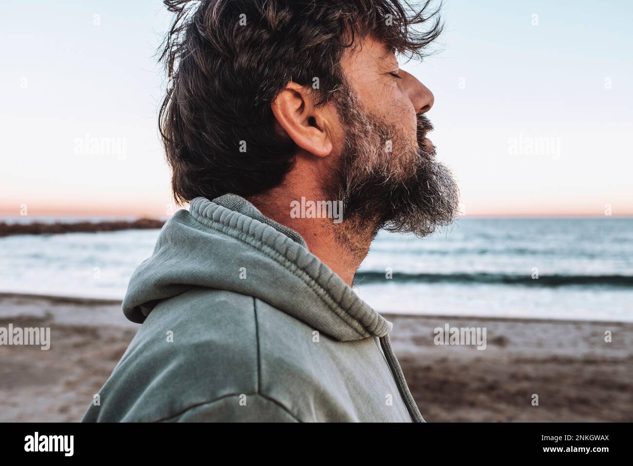 Uomo maturo con gli occhi chiusi in spiaggia Foto Stock