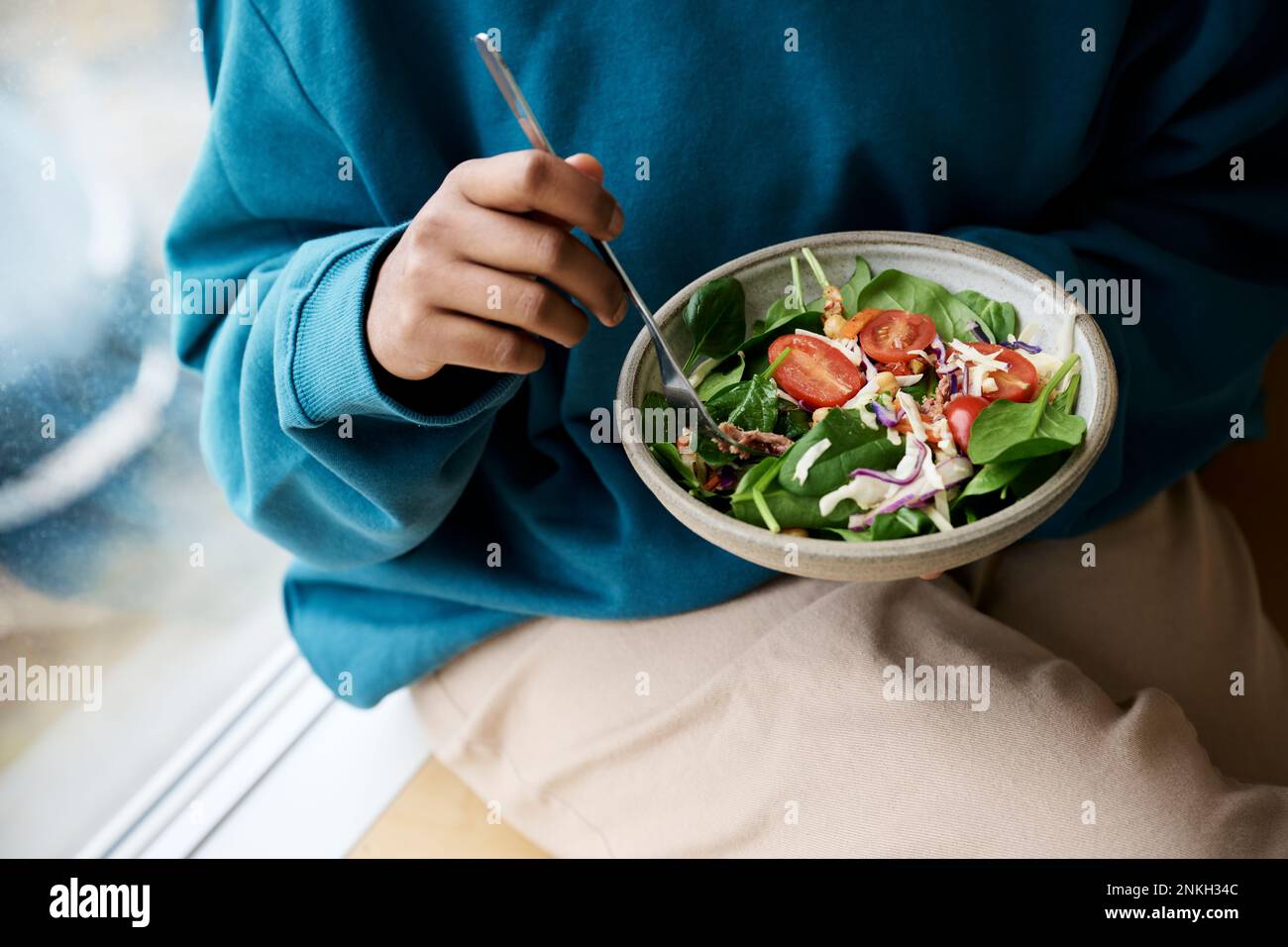 Donna che tiene ciotola di insalata fresca sana Foto Stock
