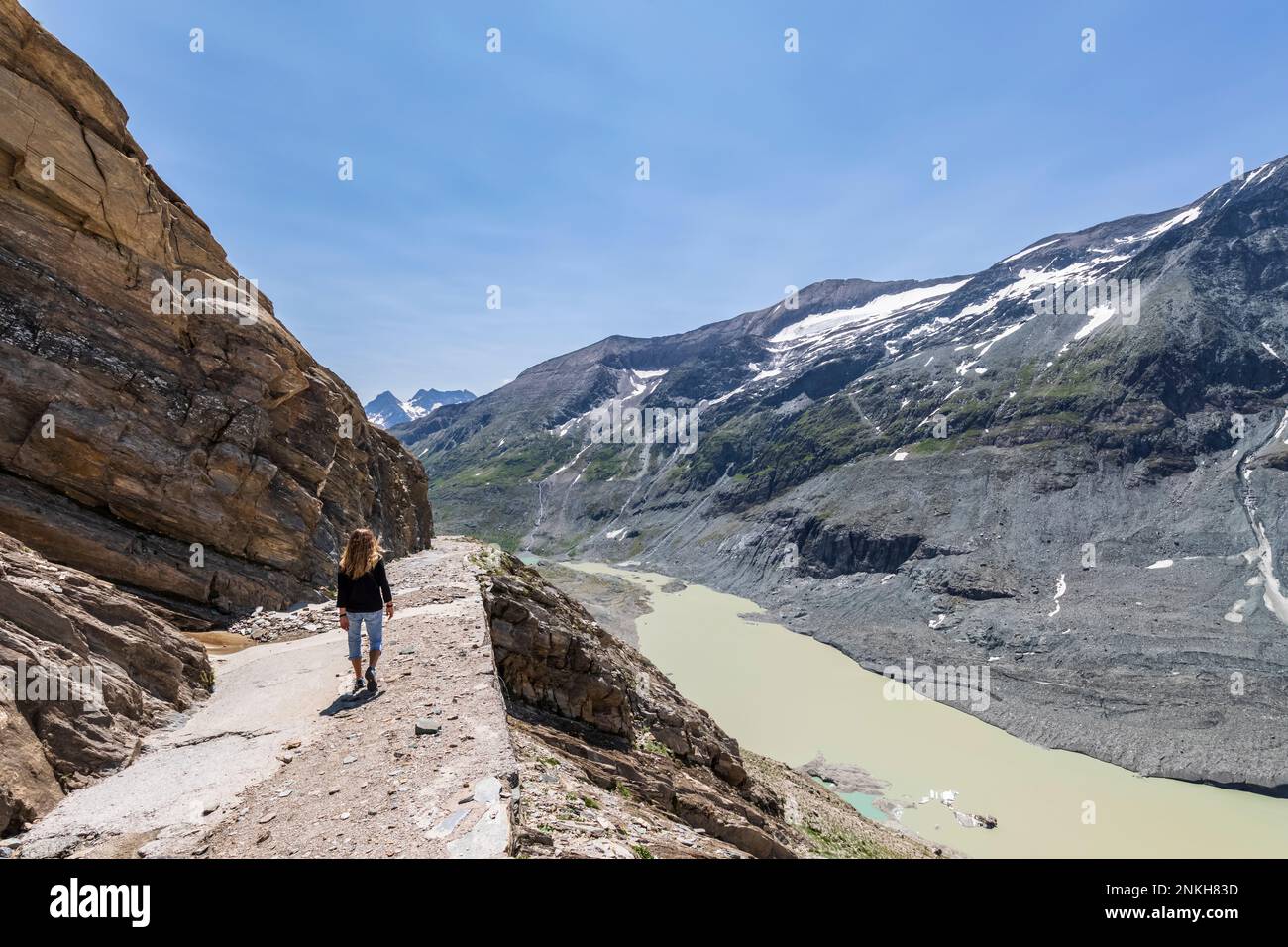 Austria, Carinzia, escursionista femminile su Gamsgrubenweg con lago Sandersee sullo sfondo Foto Stock
