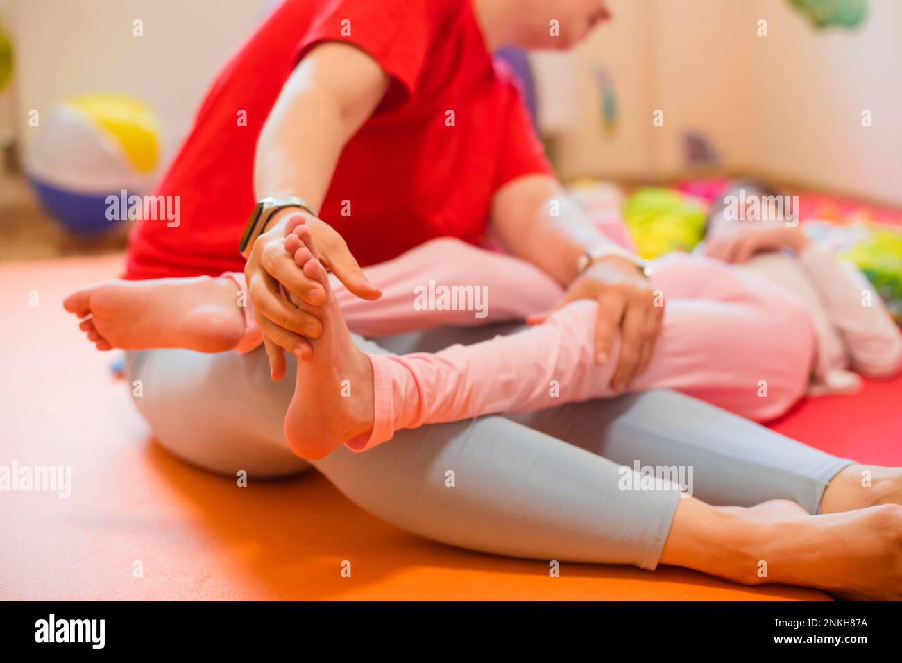 Fisioterapista che esamina il piede del paziente con paralisi cerebrale Foto Stock