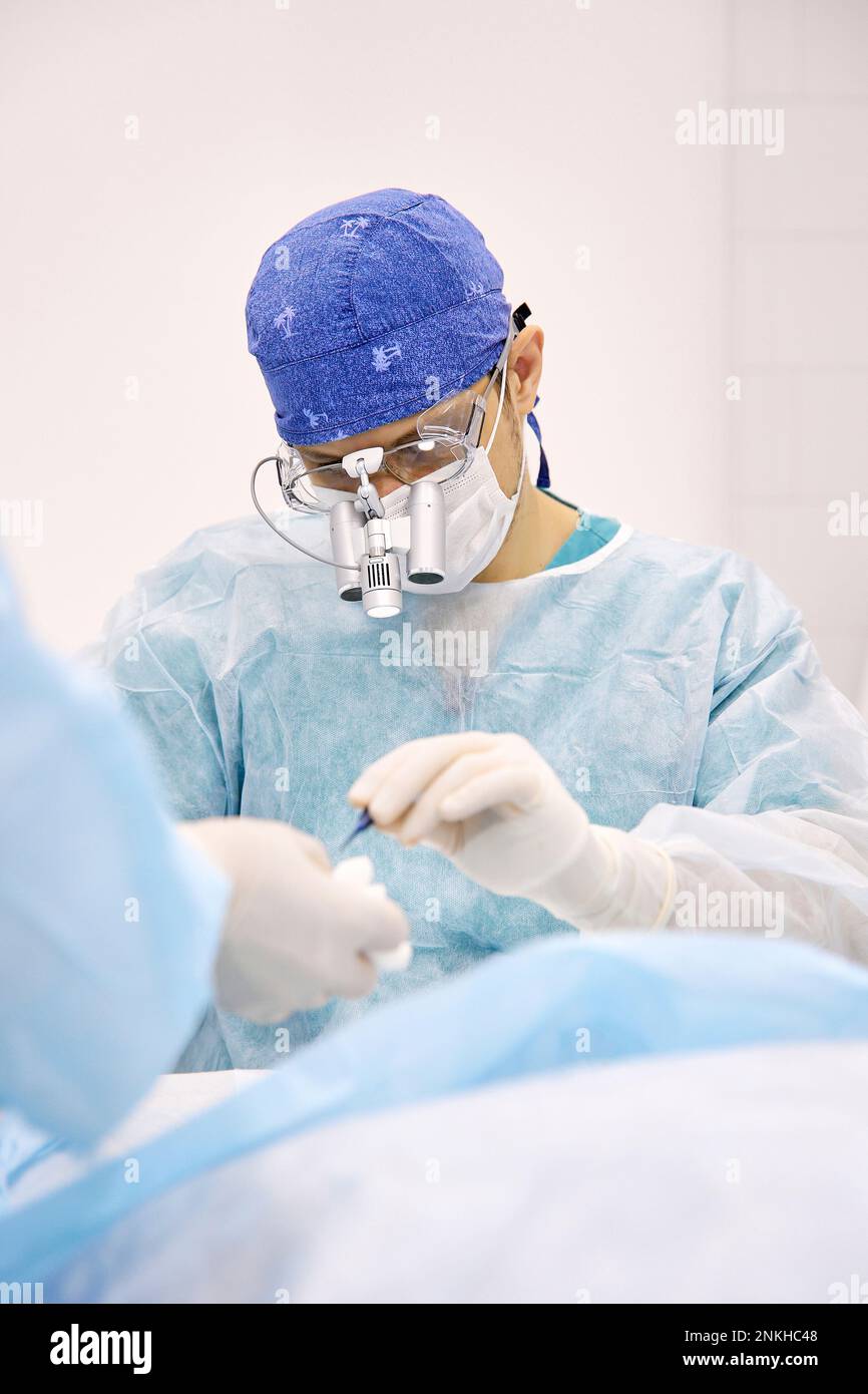 Dottore con strumenti che fanno chirurgia oculare sul paziente Foto Stock