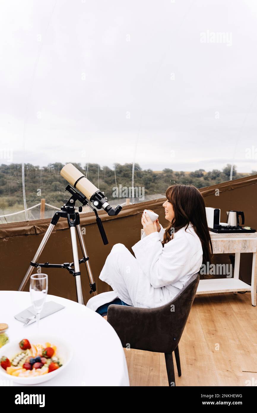 Giovane donna che si diverte a bere un caffè seduto nella cupola Foto Stock