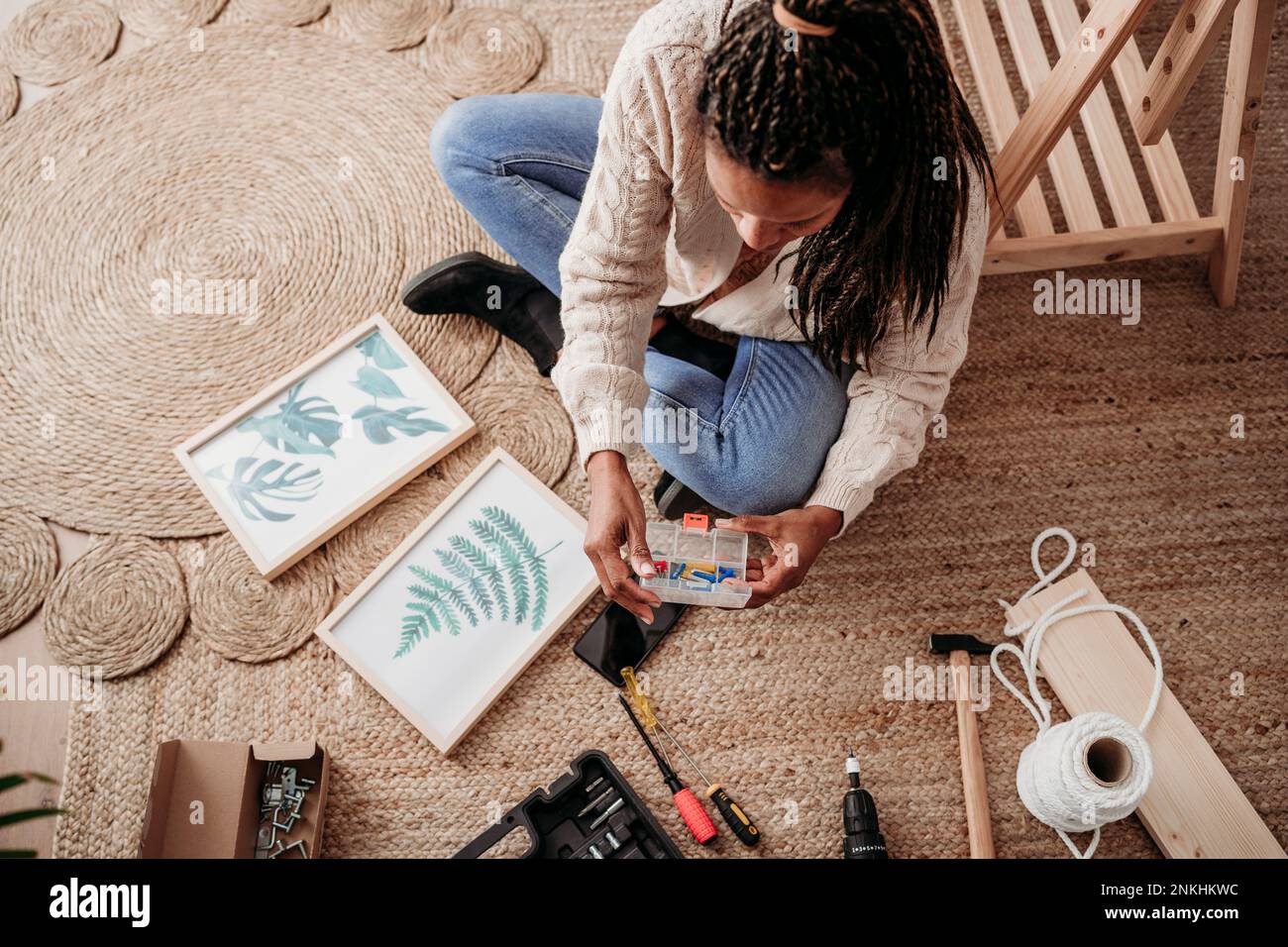 Donna che fa cornici fai da te a casa Foto Stock