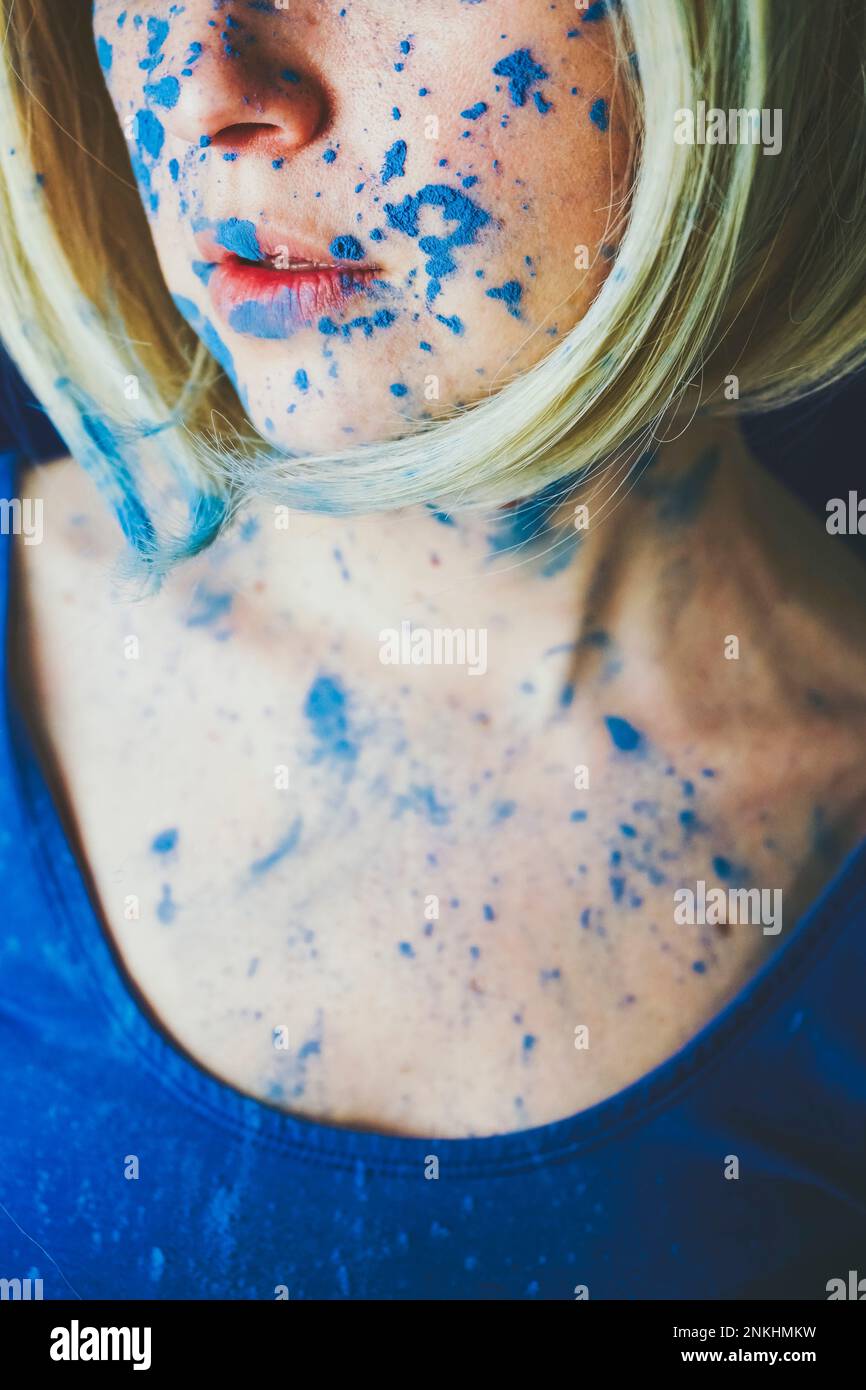 Faccia della donna coperta di vernice blu Foto Stock