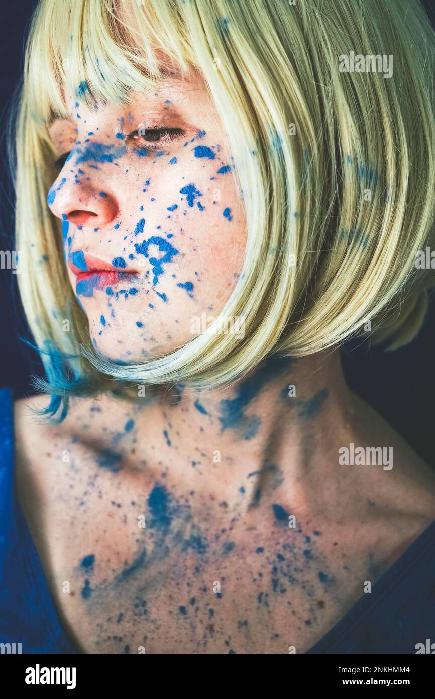 Donna bionda ricoperta di vernice blu Foto Stock