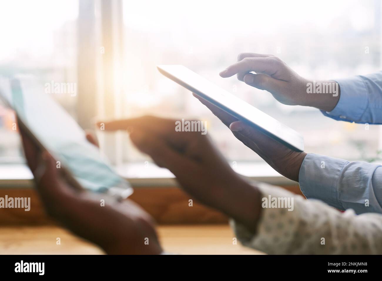 Gestire il business in modo intelligente. Primo piano di due uomini d'affari irriconoscibili che utilizzano dispositivi digitali in un ufficio. Foto Stock