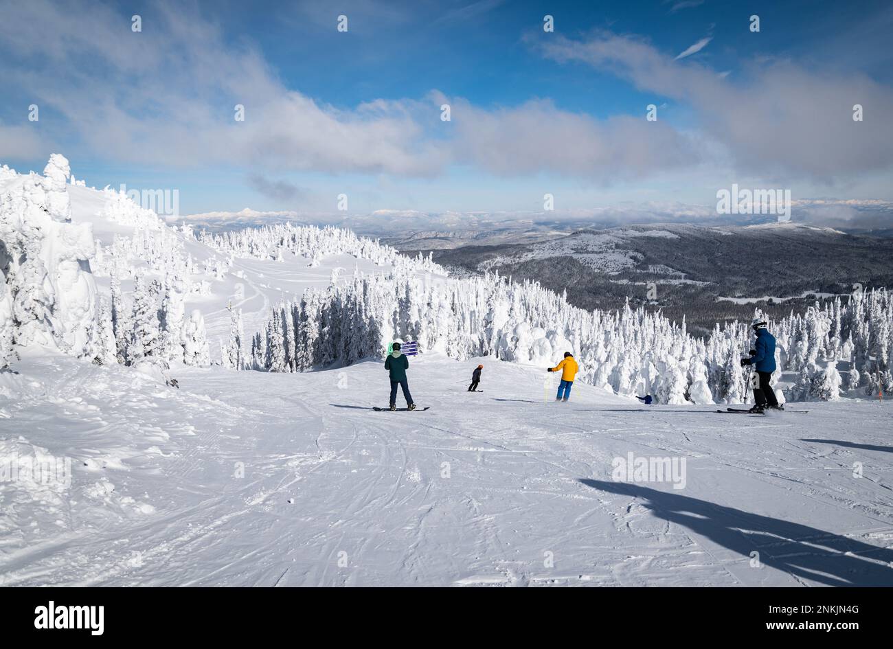 Gli sciatori e gli snowboarder iniziano a scendere lungo la montagna dallo skilift Crystal, presso la vetta del "Top of the World", presso la stazione sciistica di Sun Peaks. Foto Stock
