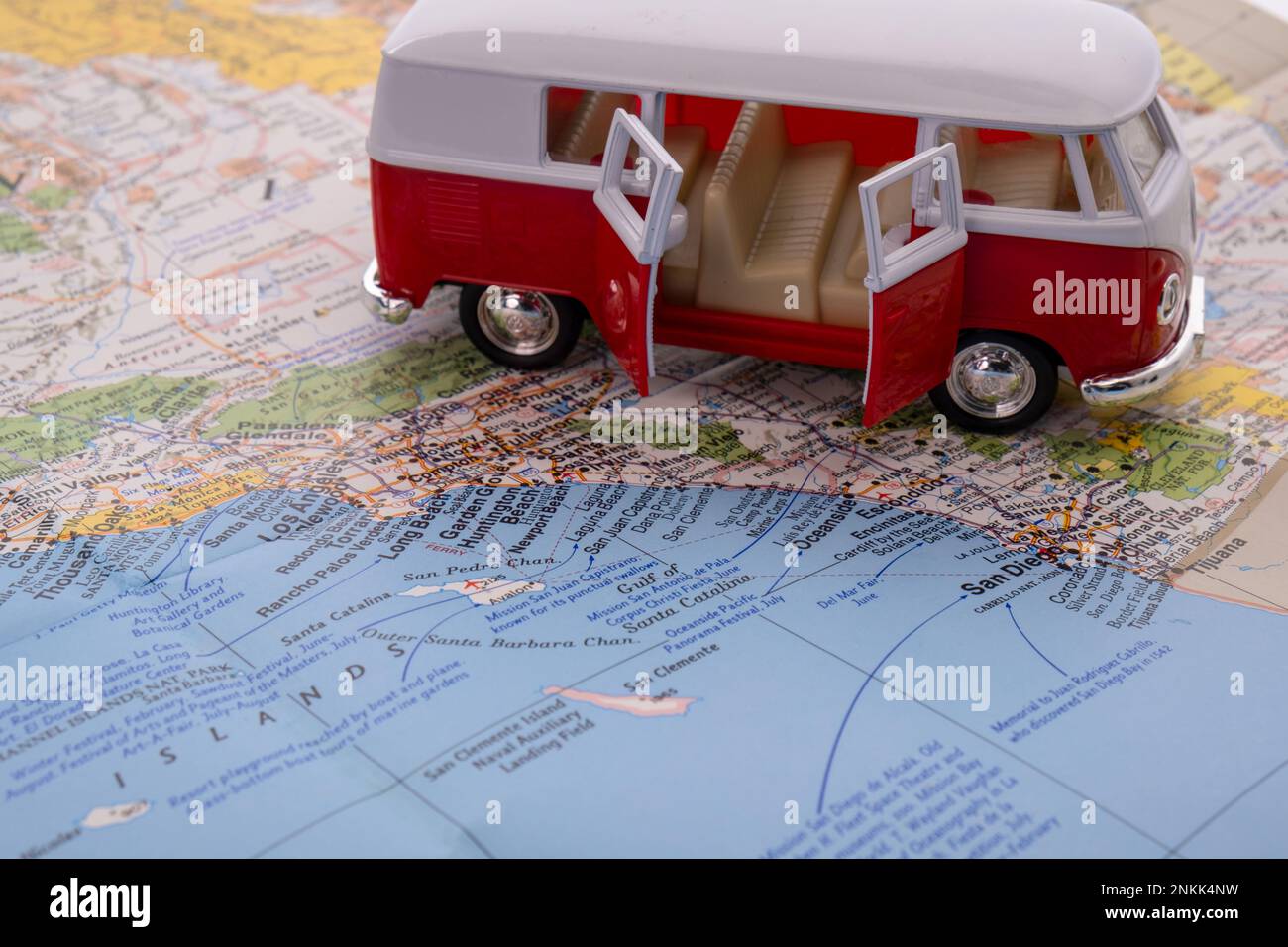 OGDEN, UTAH USA - FEBBRAIO 10 2023 Un pulmino VW rosso e bianco in miniatura con le sue porte si apre su una mappa della costa californiana che mostra San Diego, Long Beach Foto Stock