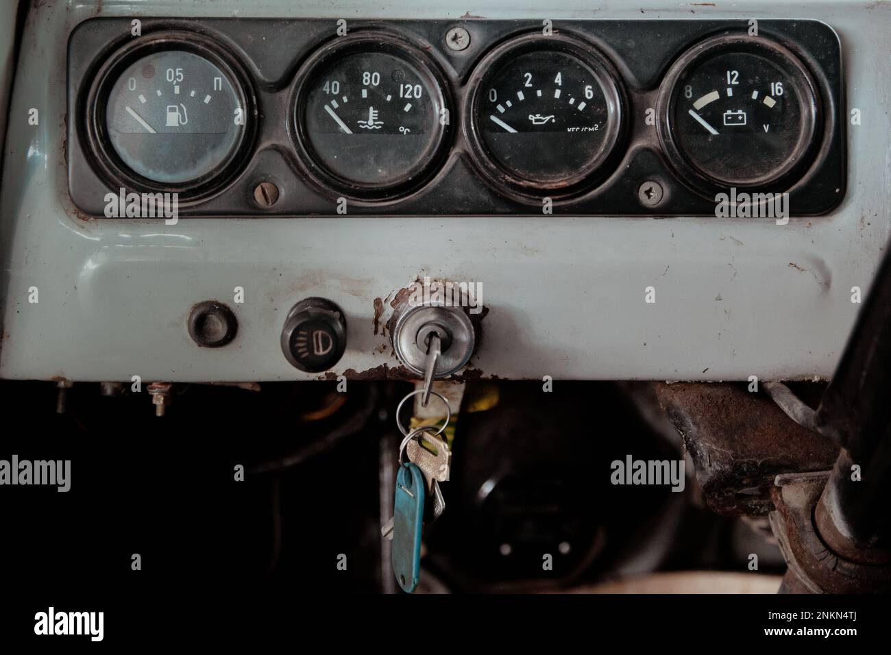 strumenti di controllo analogici di un'auto vecchia e una chiave per l'avvolgimento di un'auto a una profondità di campo bassa Foto Stock