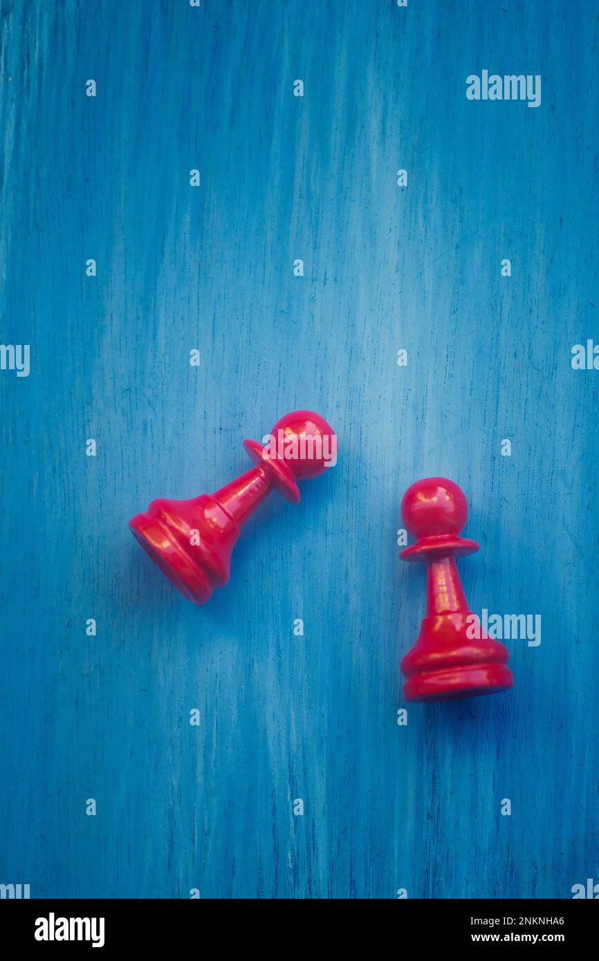 Due pedine di scacchi rosse su sfondo blu Foto Stock
