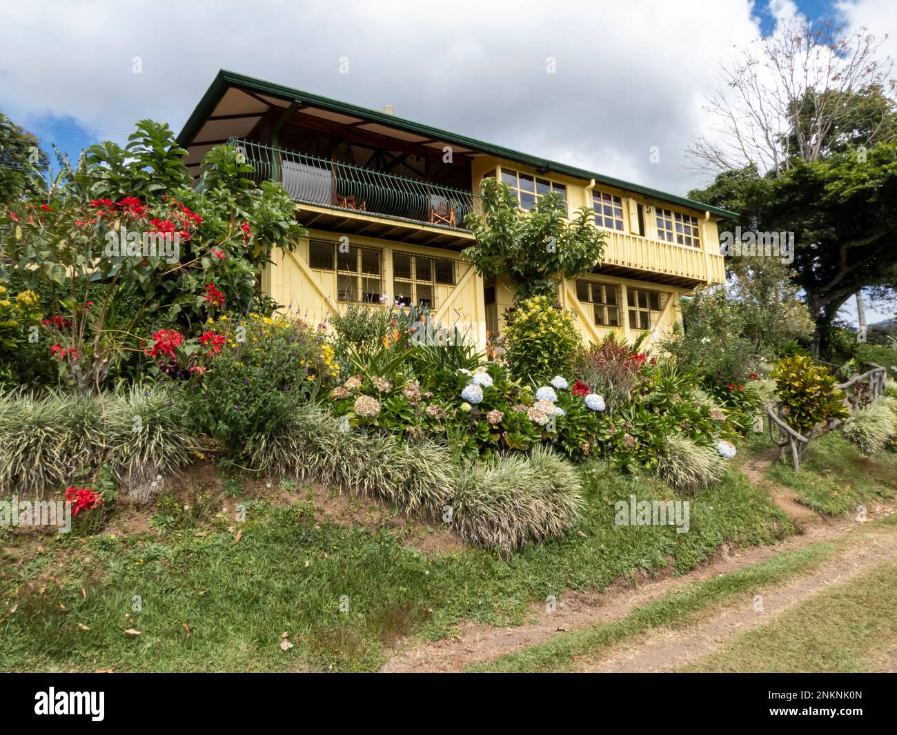Una grande casa di piantagione di caffè giallo si affaccia sulle colture di una fattoria di caffè in Alajuela in Costa Rica Foto Stock