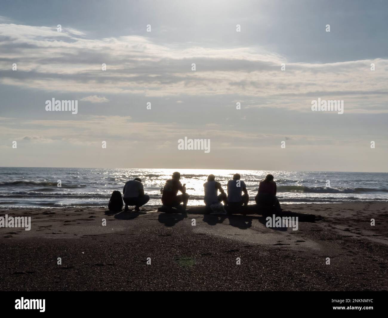 Cinque persone aspettano il sole per tramontare prima di andare a pesca in Samara Costa Rica Foto Stock