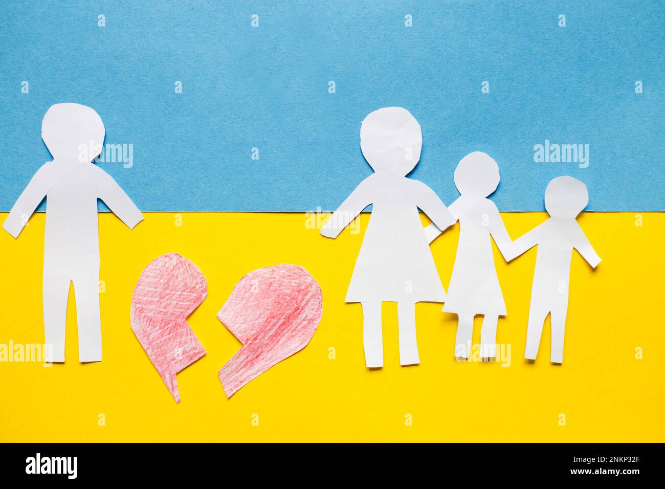 carta tagliata famiglia divisa sullo sfondo della bandiera ucraina. concetto di guerra di arresto. Foto Stock