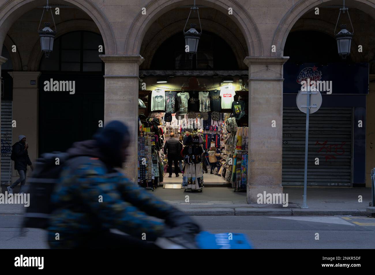 Il primo negozio di souvenir apre prima dei suoi concorrenti nelle strade di Parigi, mentre la consegna della bicicletta passa Foto Stock