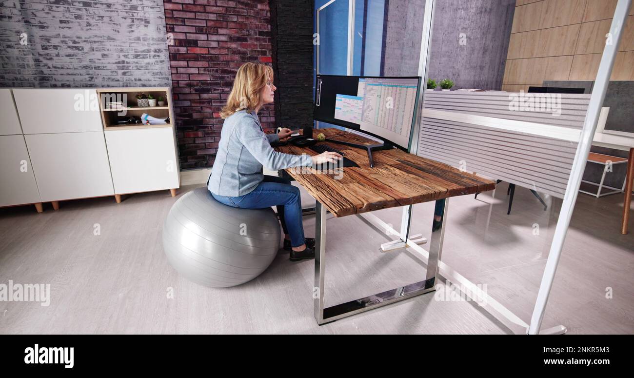 Correggere la postura alla scrivania in ufficio usando la sfera di idoneità Foto Stock