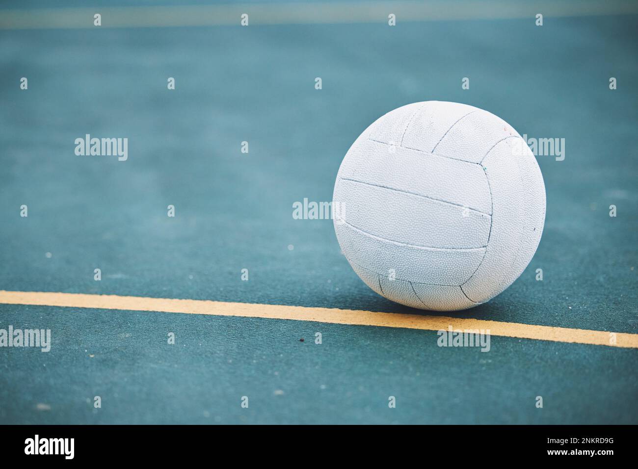 Netball a terra su un campo sportivo per una partita, allenamento o esercizio all'aperto su un campo. Sport, fitness e palla bianca sul pavimento per una partita Foto Stock