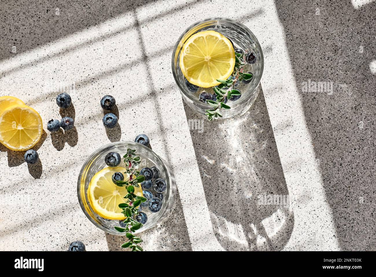 Fresco estate bere mojito mirtillo o mirtillo limonata ghiacciata con fettine di limone, mirtilli, ghiaccio e timo. Foto Stock