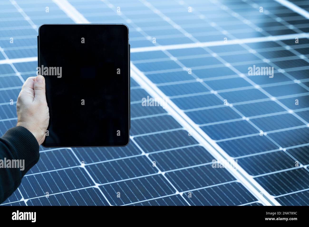 Tablet vuoto con spazio copia con alcuni pannelli solari sullo sfondo Foto Stock