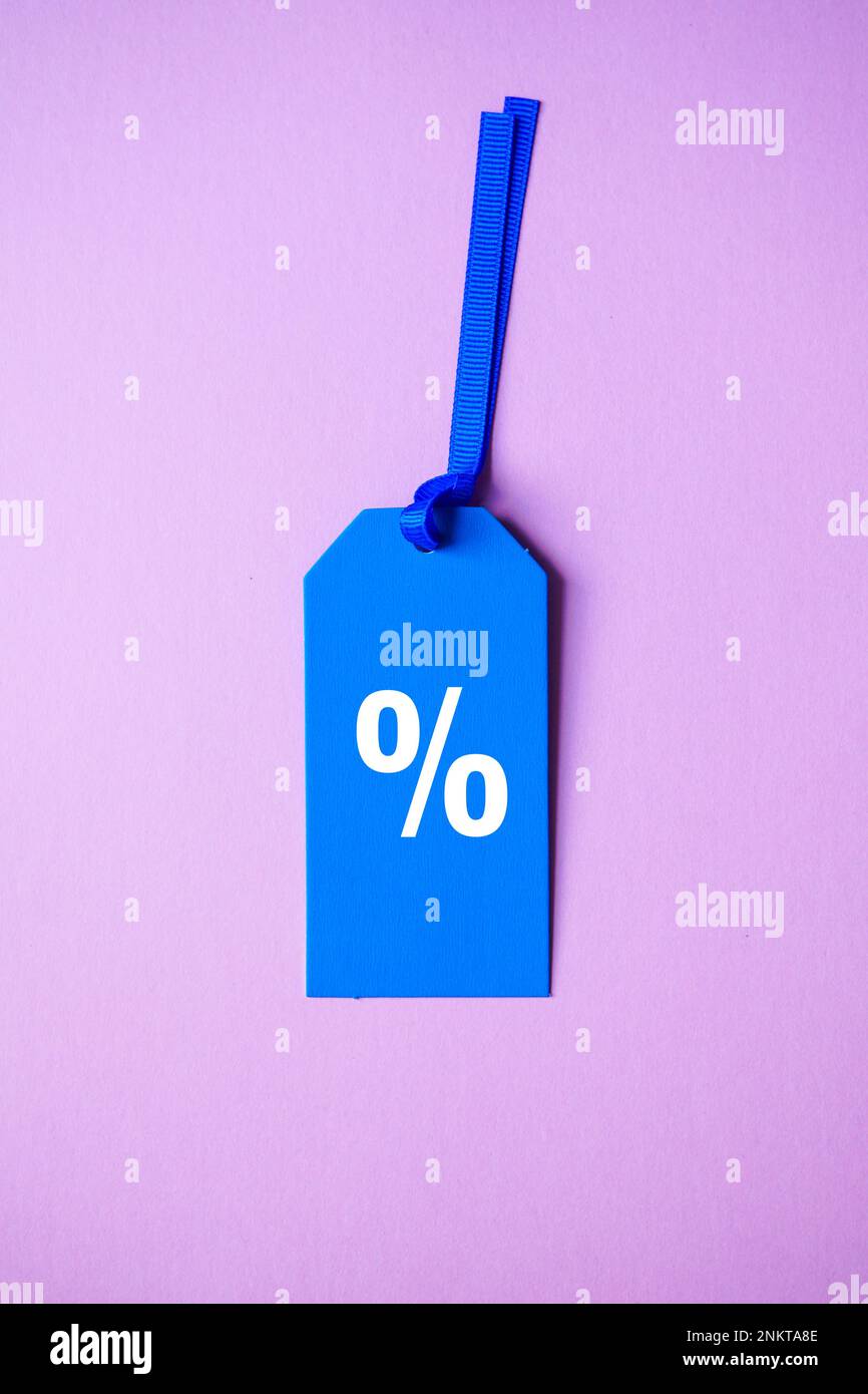 simbolo di percentuale sulla fascia di prezzo blu, sfondo rosa Foto Stock