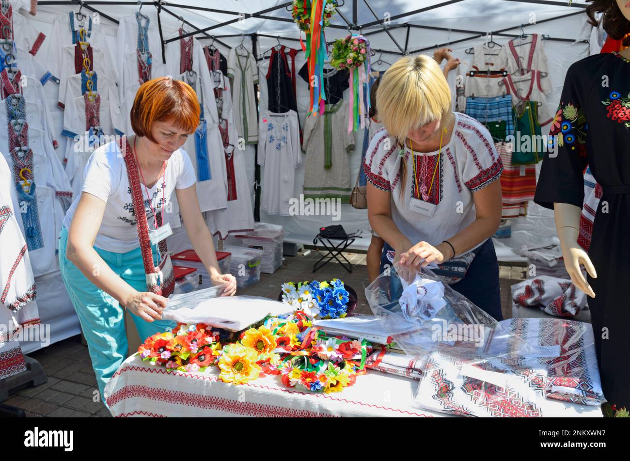 Le donne venditori mettono i vestiti sul banco in attesa per i clienti prima di aprire al ricamo nazionale ucraino camicie Street stalle. Kiev, Ucraina Foto Stock