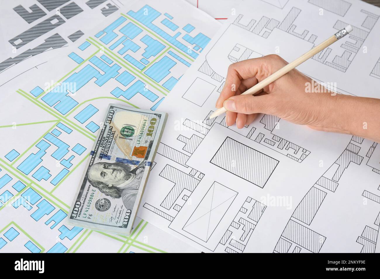 Cartografo con soldi che disegnano mappa catastale, primo piano Foto Stock